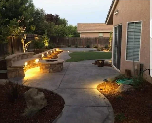 Patio fire pit and lighting built into a masonry patio by Specialty Landscape