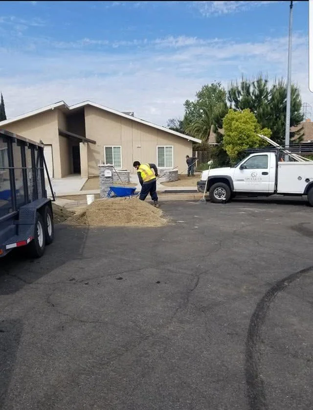 Dump trailer loaded with tree debris during a removal by Specialty Landscape
