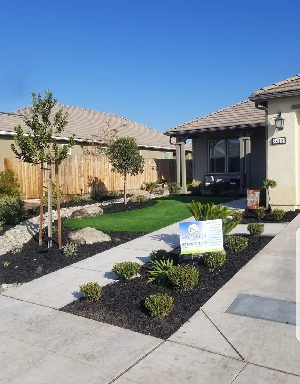 Newly installed front yard turf with a Specialty Landscape yard sign