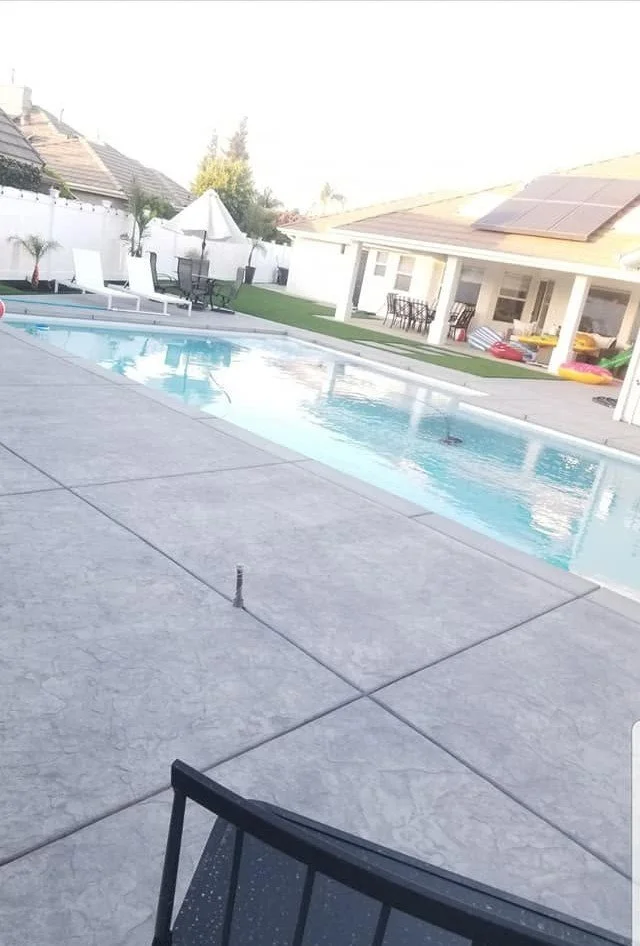 New concrete pool deck and surrounding landscaping by Specialty Landscape in Selma