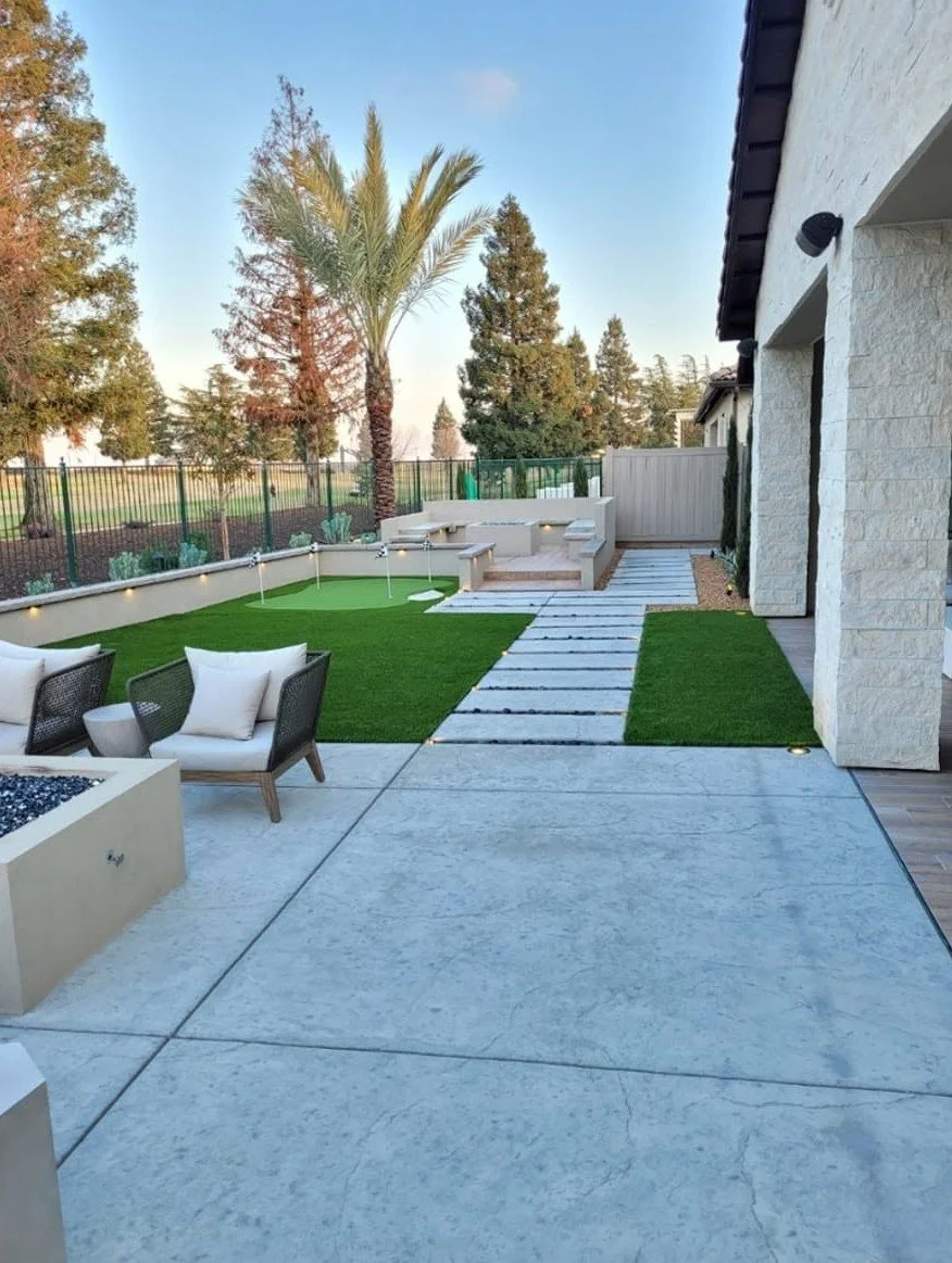 Backyard walkway and seating shaded by established trees by Specialty Landscape
