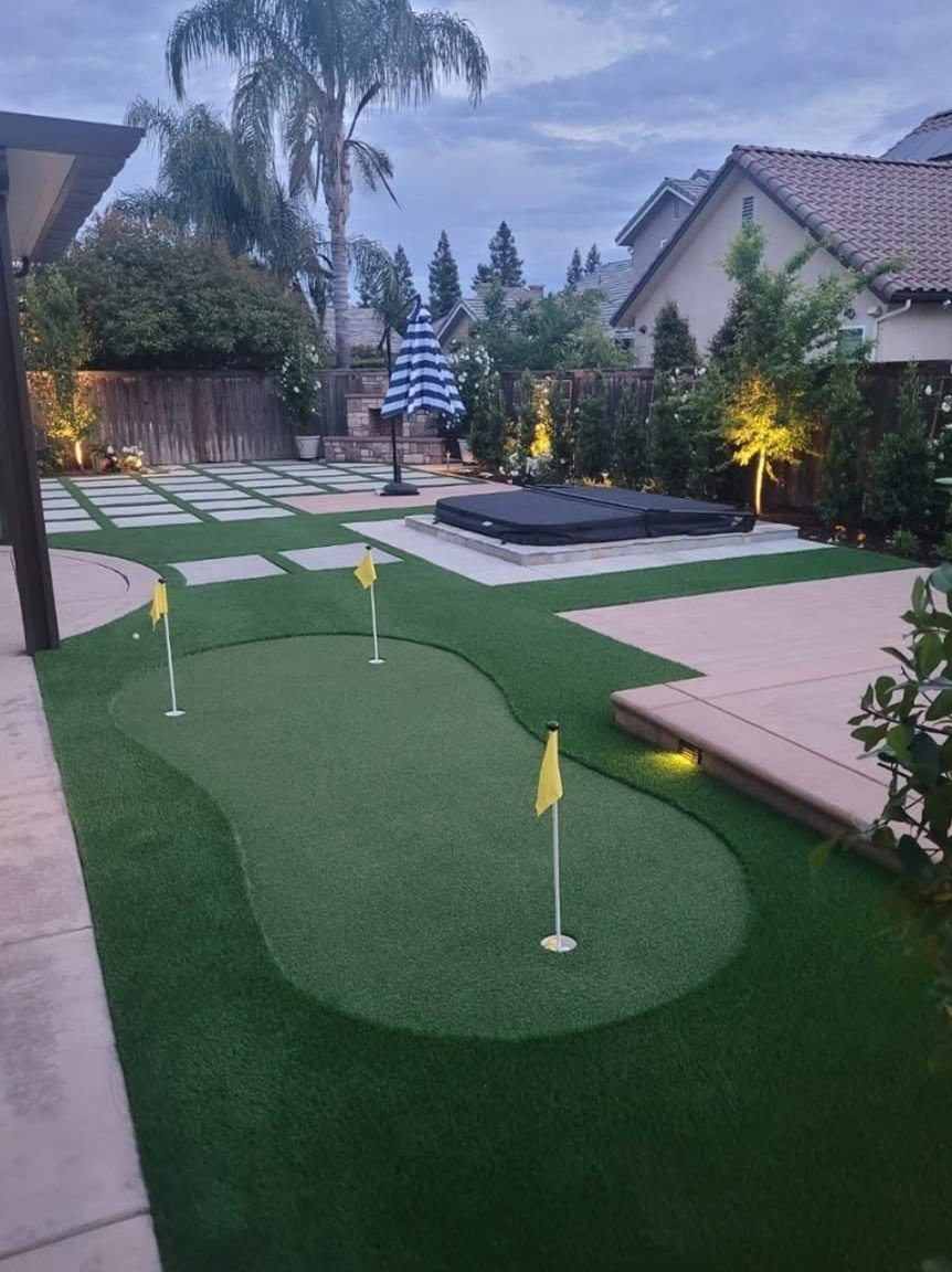 Artificial turf putting green with practice flags by Specialty Landscape