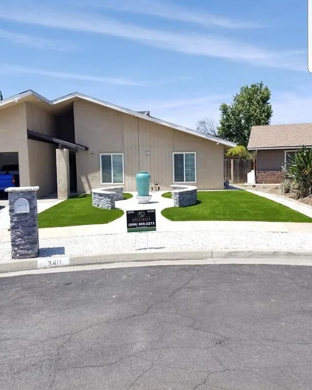 Front-yard artificial turf between block columns by Specialty Landscape