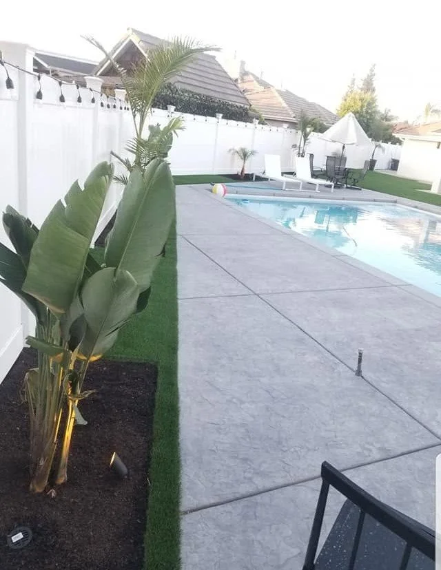 Pool deck and planting beds in a finished Kerman backyard by Specialty Landscape