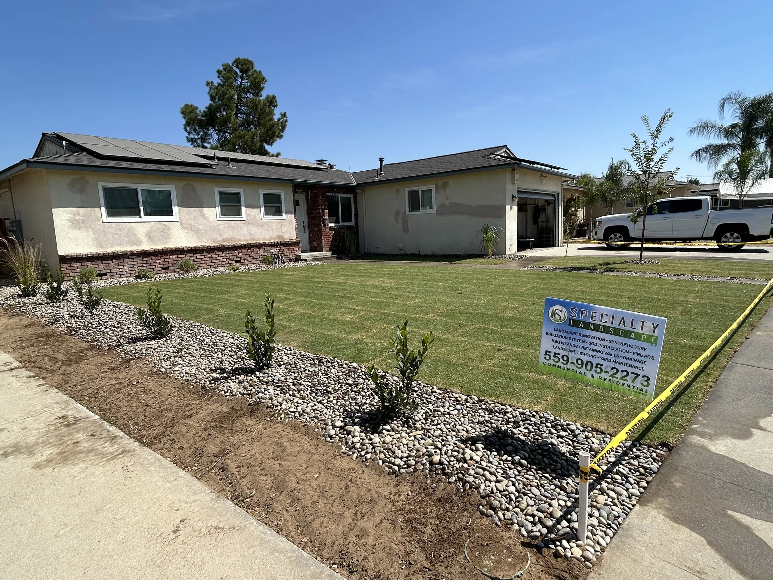 Specialty Landscape trucks in the driveway of a completed Clovis project