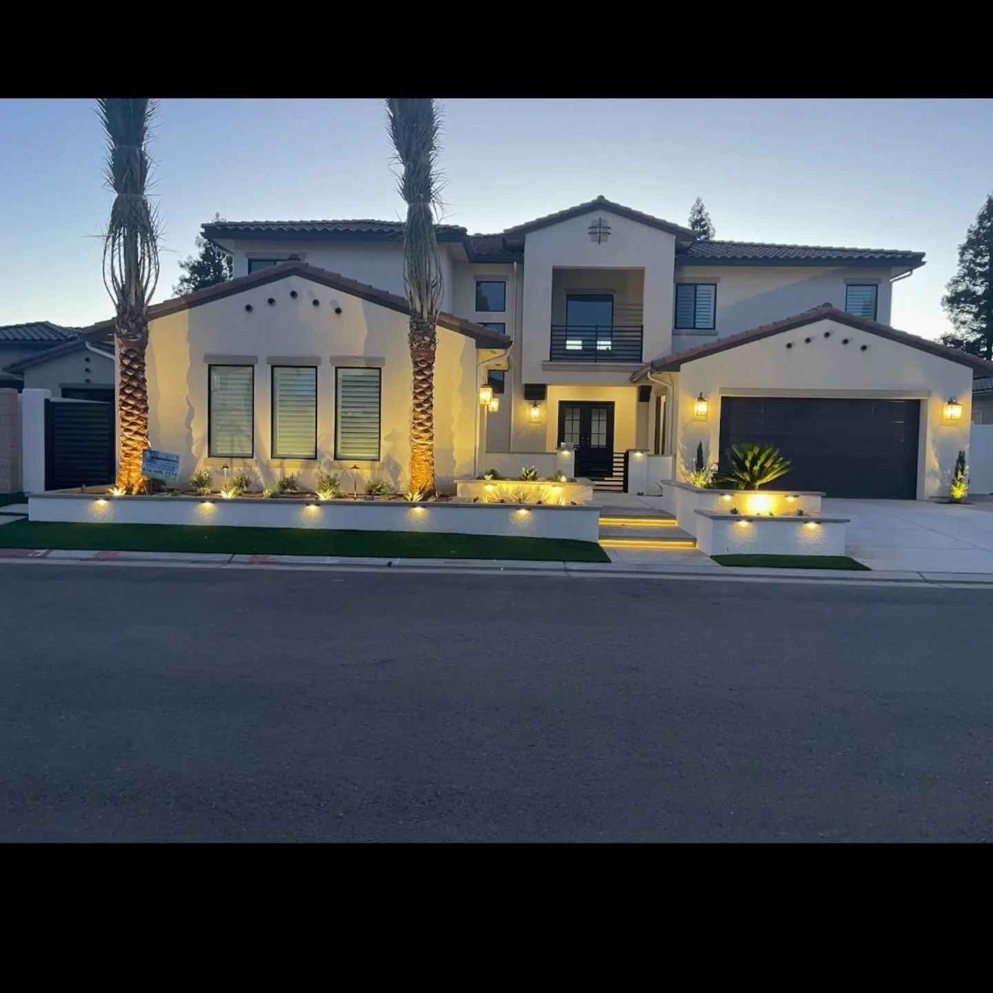 Home frontage lit after dark by landscape lighting from Specialty Landscape