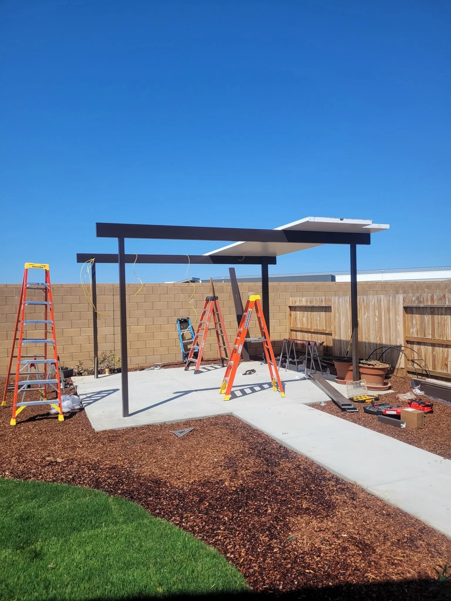 Alumawood patio cover frame going up on site by Specialty Landscape