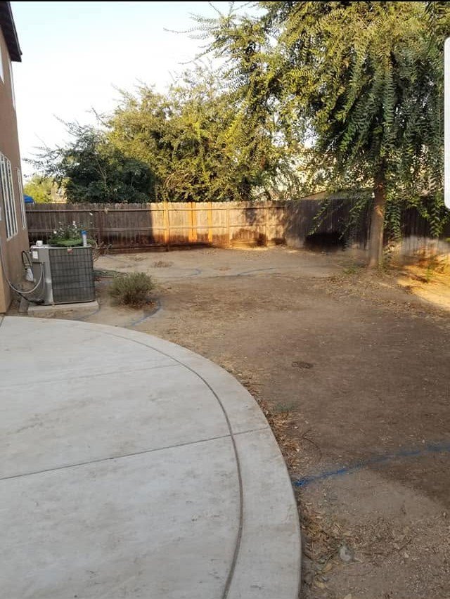 Yard cleared and leveled after stump removal by Specialty Landscape