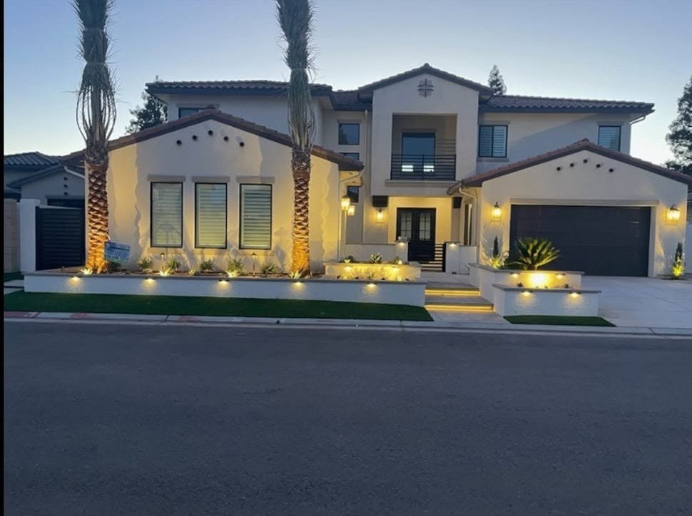 Two-story home front lit at dusk by landscape lighting from Specialty Landscape