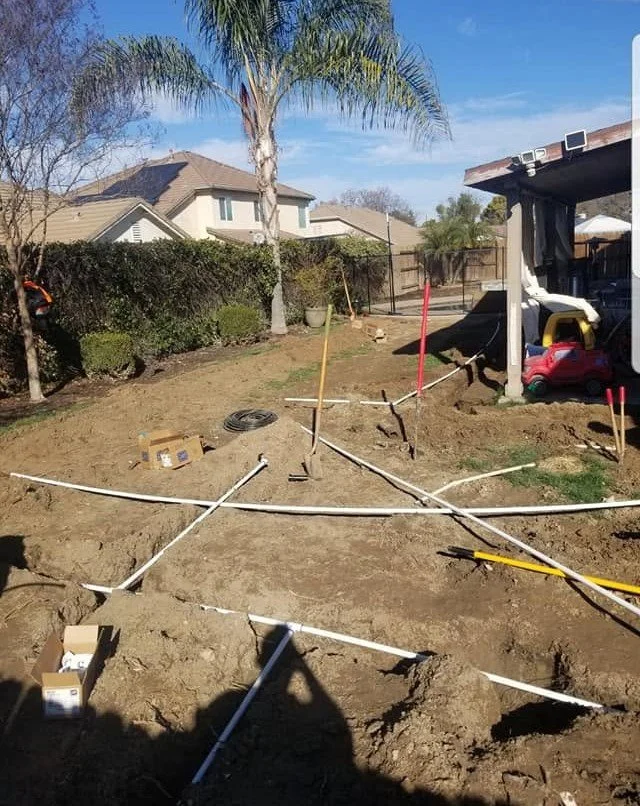 Irrigation mainline and lateral pipe laid out in an open trench by Specialty Landscape