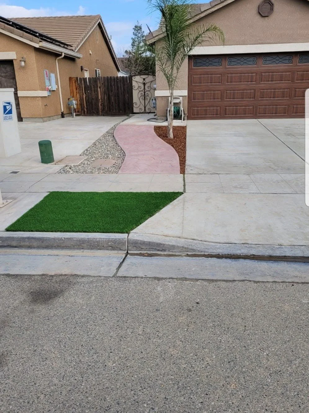 Artificial turf strip along a driveway by Specialty Landscape