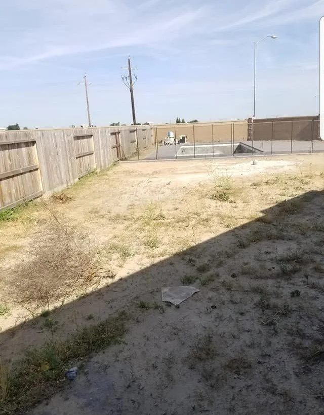 Old fence line and bare yard before a fence tear-out and replacement by Specialty Landscape