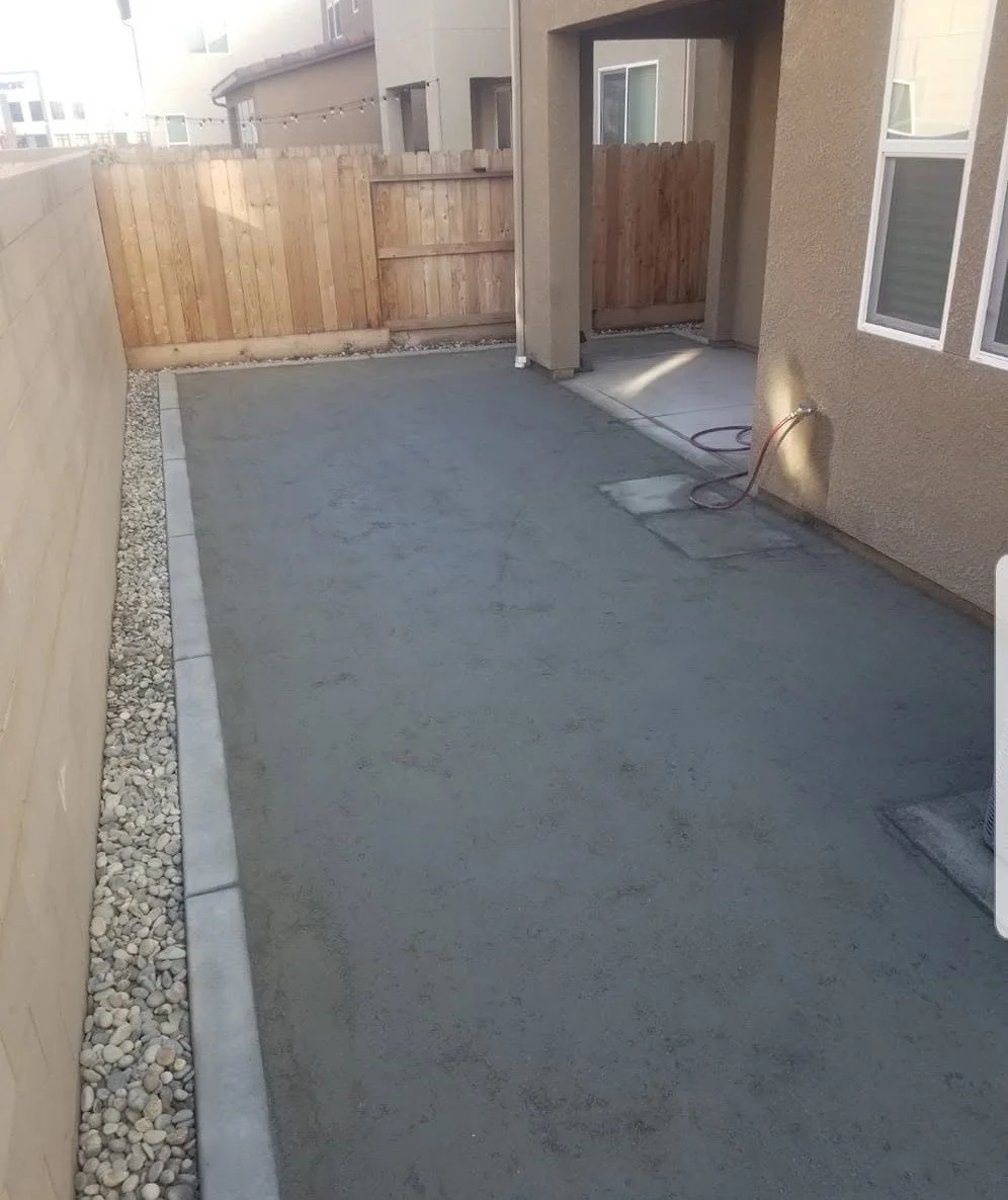 Side yard slab with a gravel border channeling surface water by Specialty Landscape