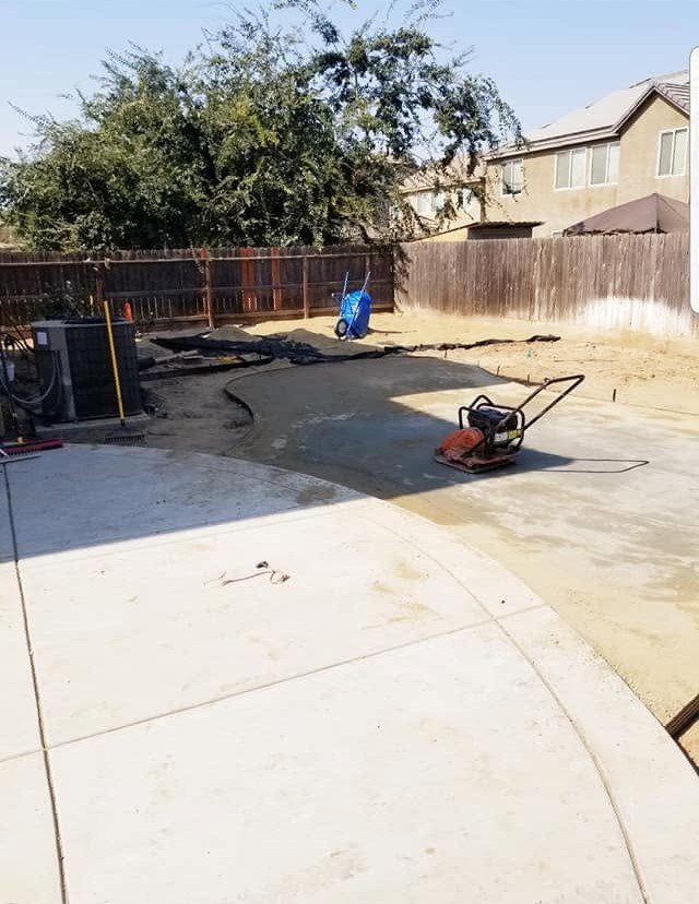 Crew running a plate compactor while prepping a new concrete hardscape by Specialty Landscape