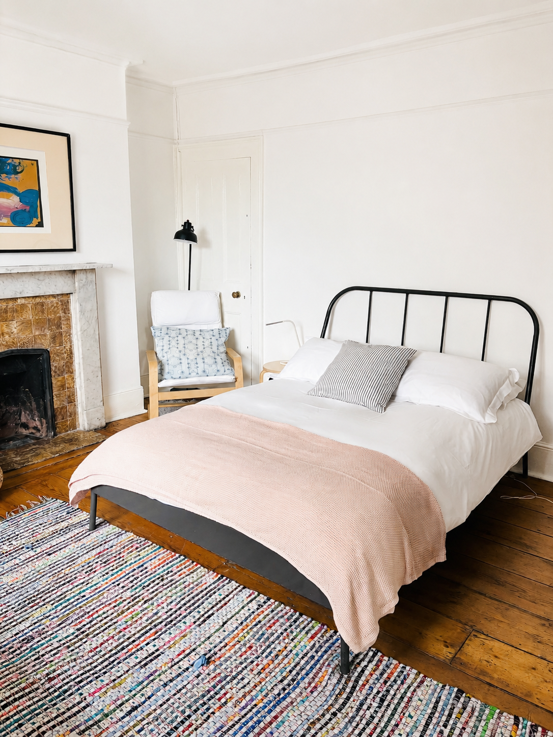Room 2 street-facing double bedroom with pink throw and original fireplace at Central Victorian House in Camden Town