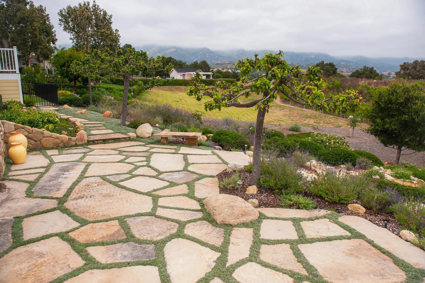 Flagstone garden terrace and planted paths overlooking the hills at Sierra Madre