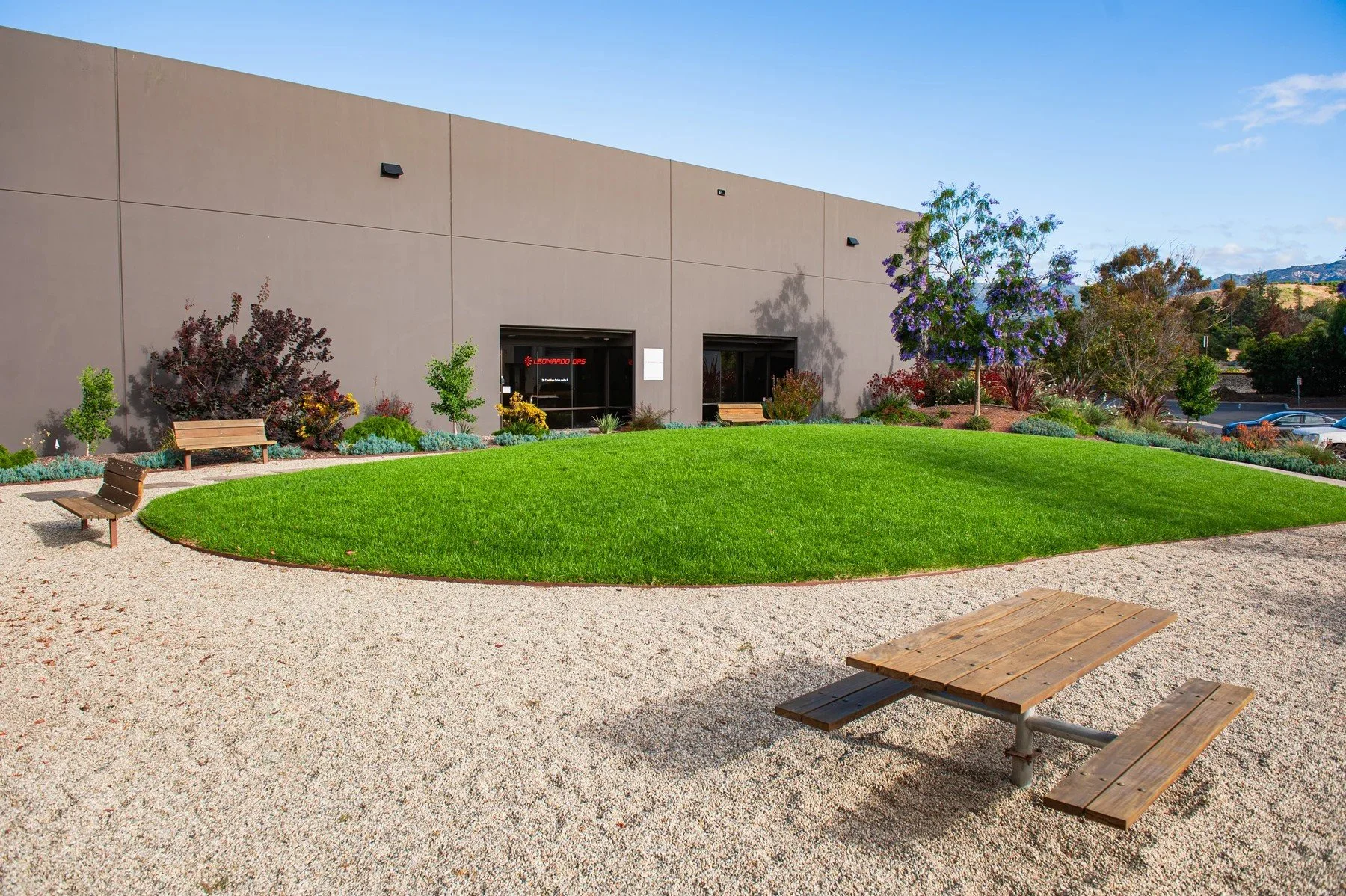 Curving courtyard lawn and an outdoor table beside 26 Castilian