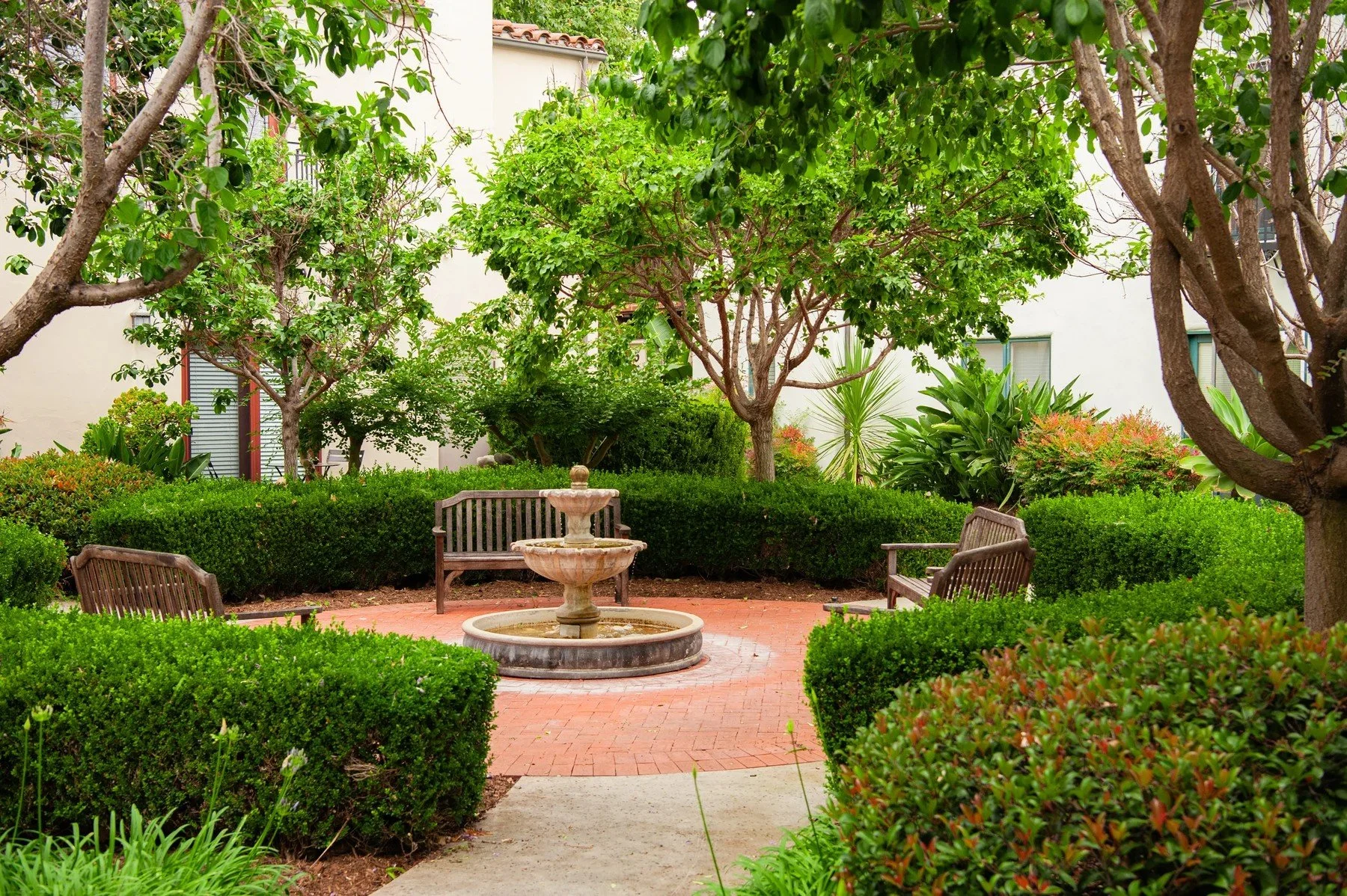 Small fountain and garden seating within a hedged courtyard at Maravilla