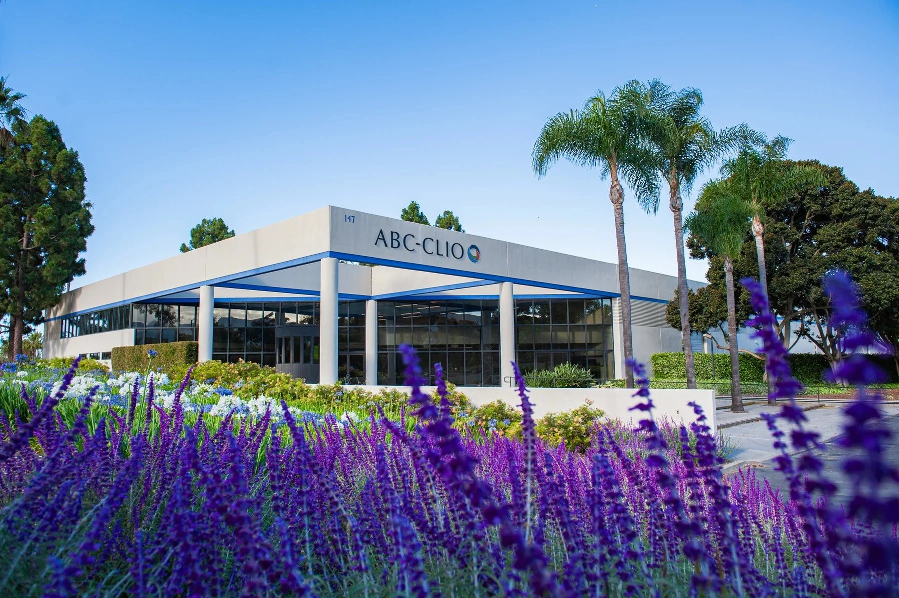 147 Castilian Drive building sign above a purple flower border