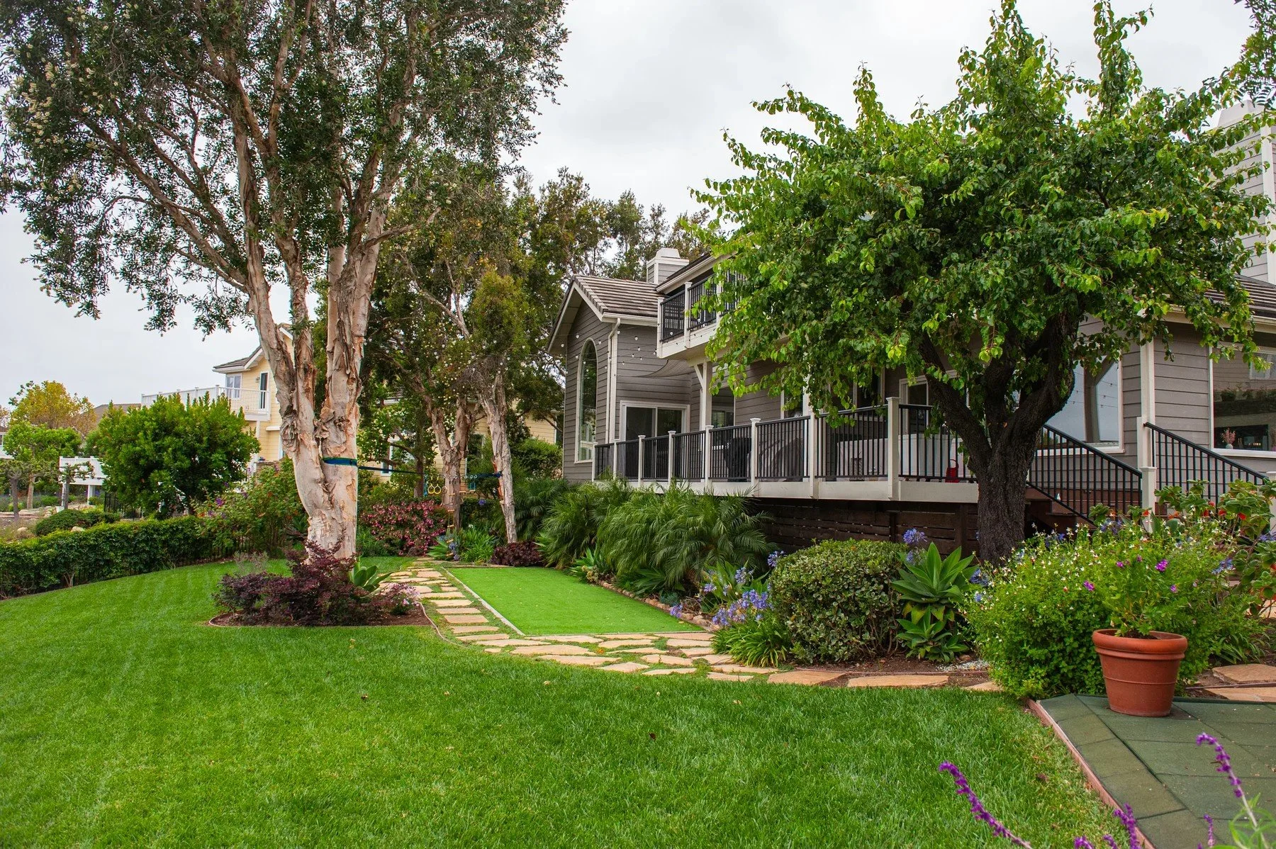 Garden lawn and stepping-stone path beneath mature trees at Sierra Madre