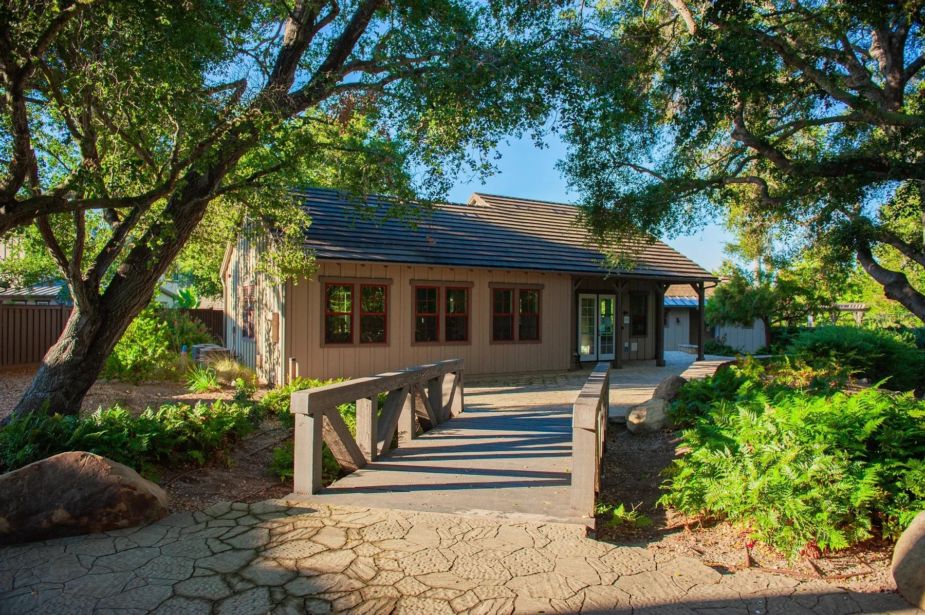 Wooden footbridge leading toward a Tree Farm community building