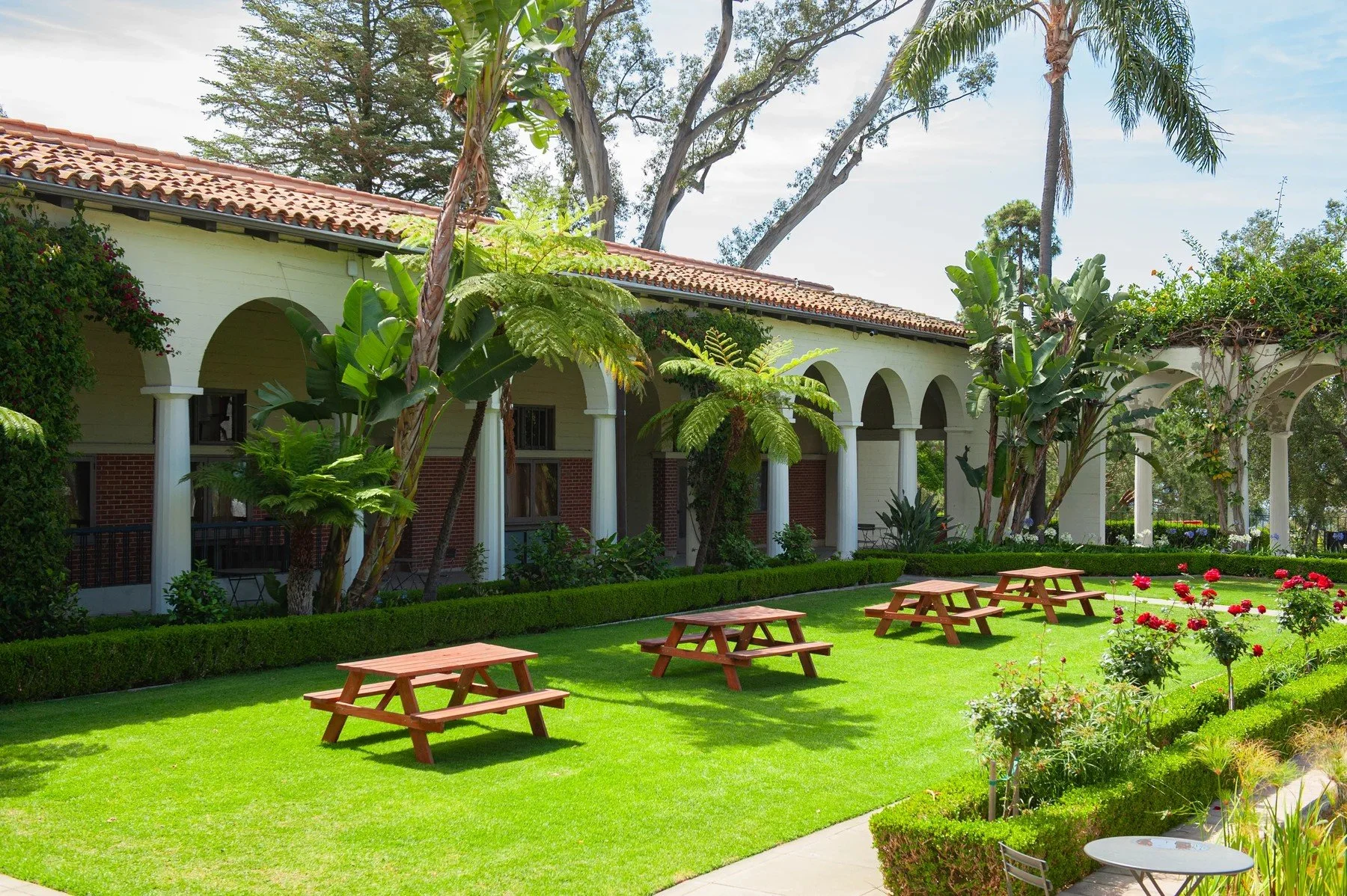 Palm trees and picnic tables beside an arched walkway at Riviera Park