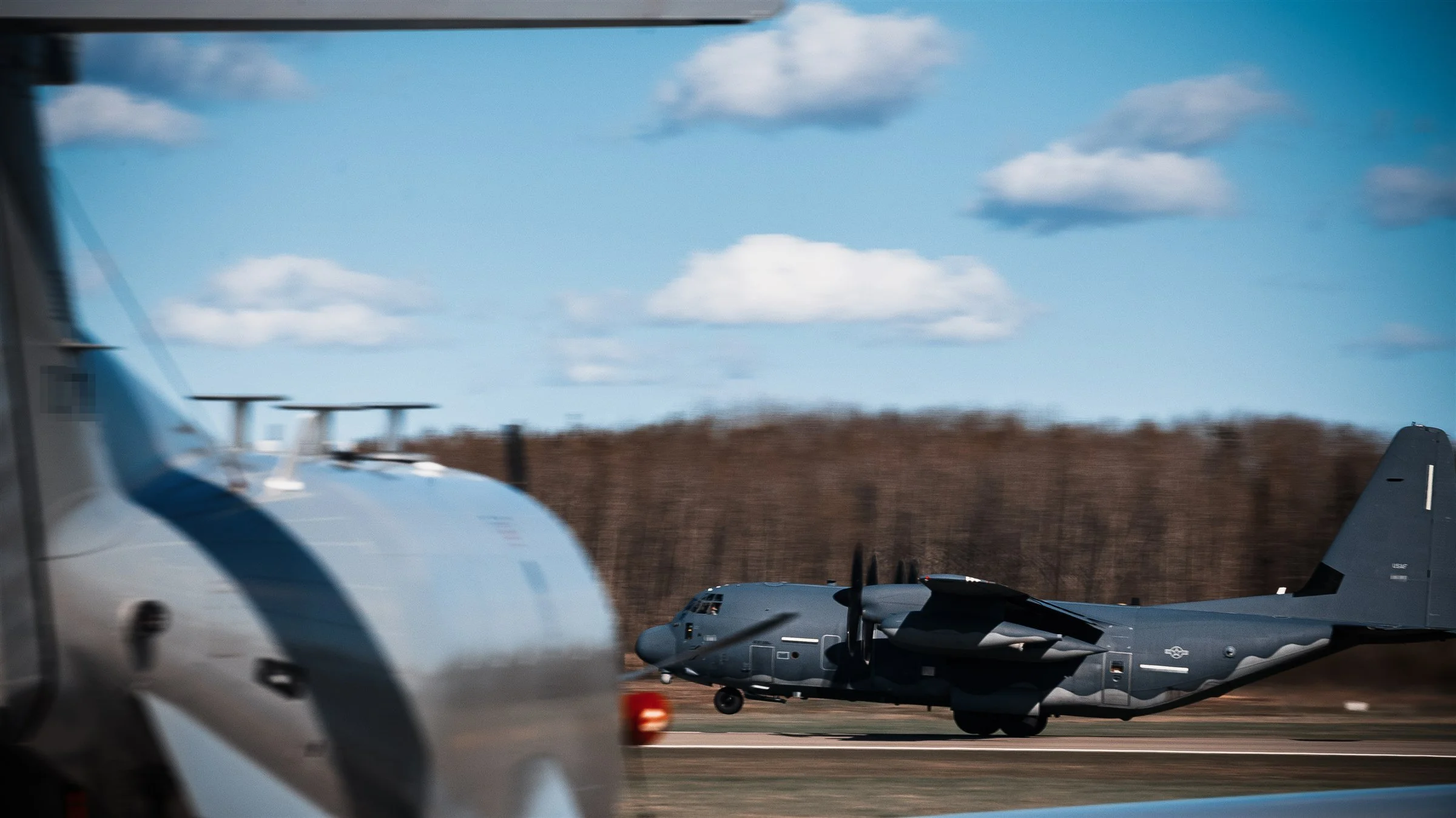 MC-130 special operations aircraft framed through the body of a foreground aircraft