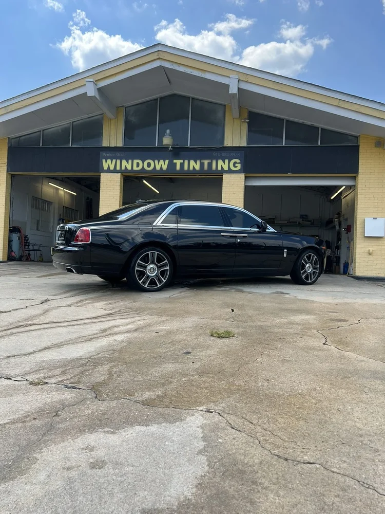 Black luxury sedan with tinted windows pulling out of the Perfect Shade bay