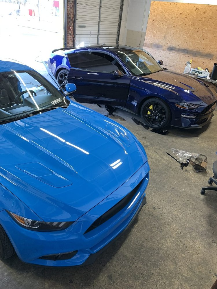 Bright blue Ford Mustang being tinted inside the Perfect Shade bay