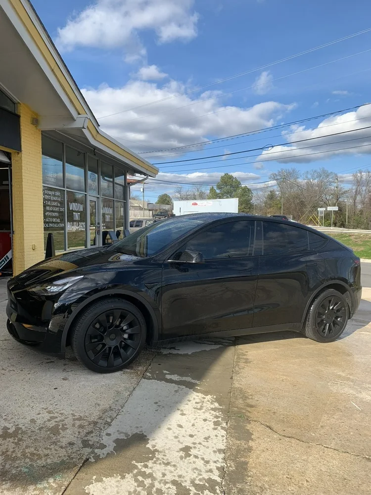 Black Tesla Model Y with tinted windows outside Perfect Shade