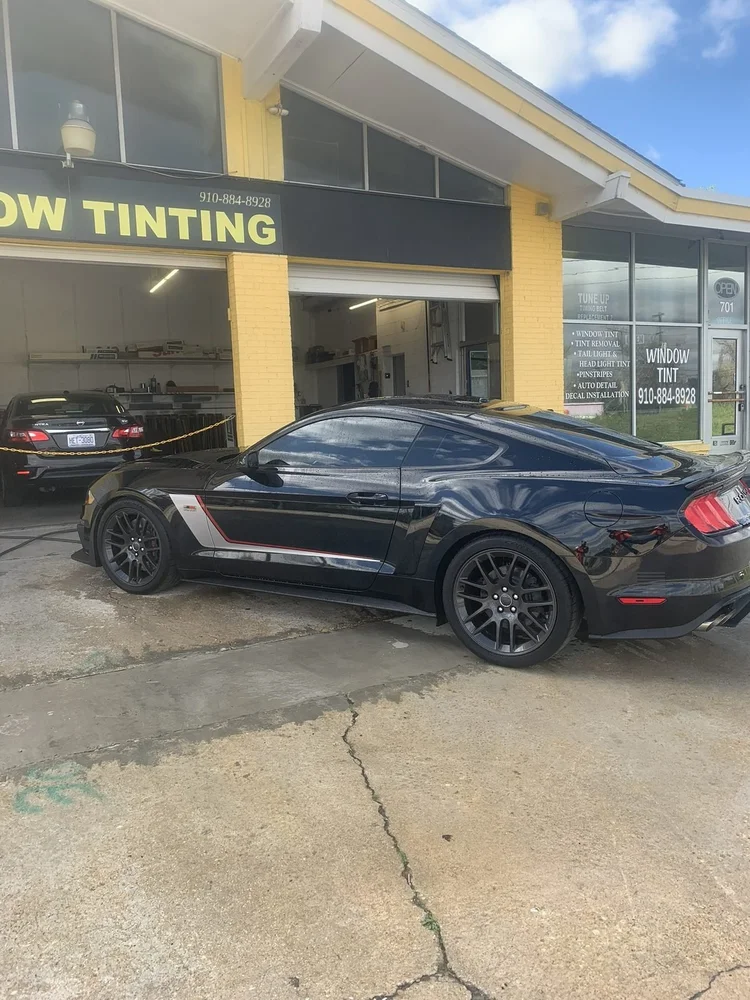 Black Ford Mustang with tinted windows in front of Perfect Shade