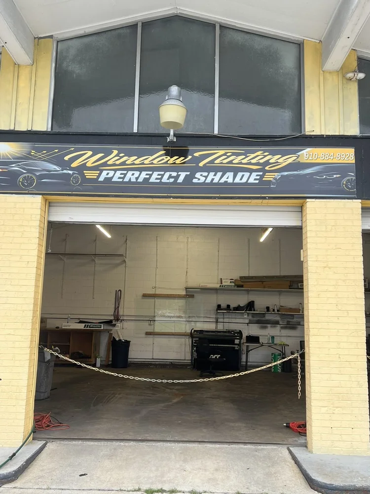 Perfect Shade Window Tinting sign above the open shop bay