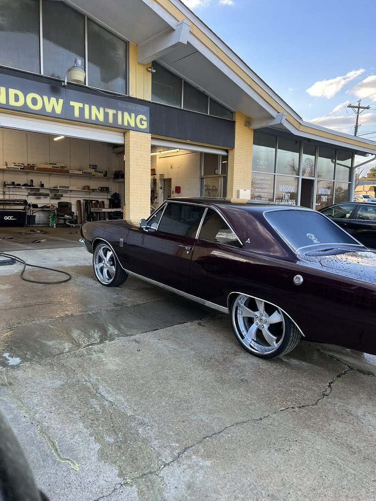 Maroon classic Chevrolet muscle car with tinted windows outside the shop