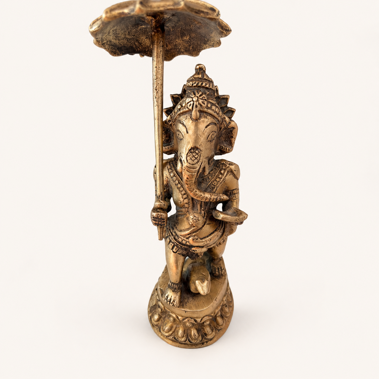 Standing Ganesha figure beneath a parasol