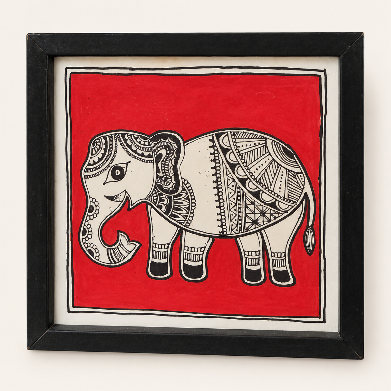 Elephant figure with black patterned details against a red background