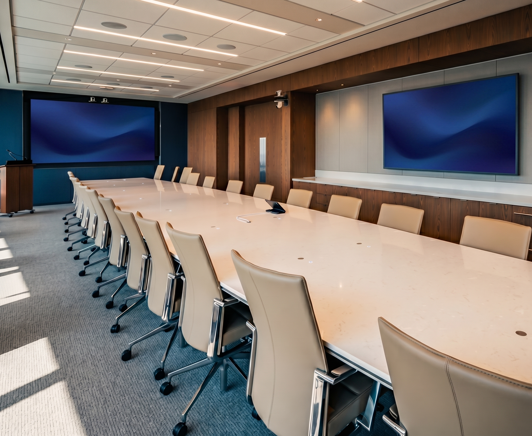 Enterprise boardroom with a long conference table, dual displays, and ceiling microphones