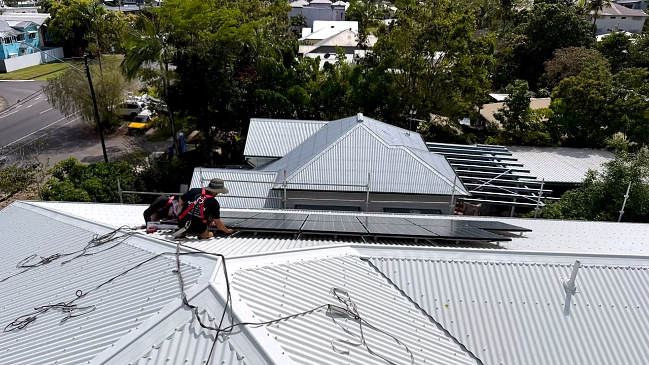 Workers on a Cairns roof putting solar panels back on during a recommission