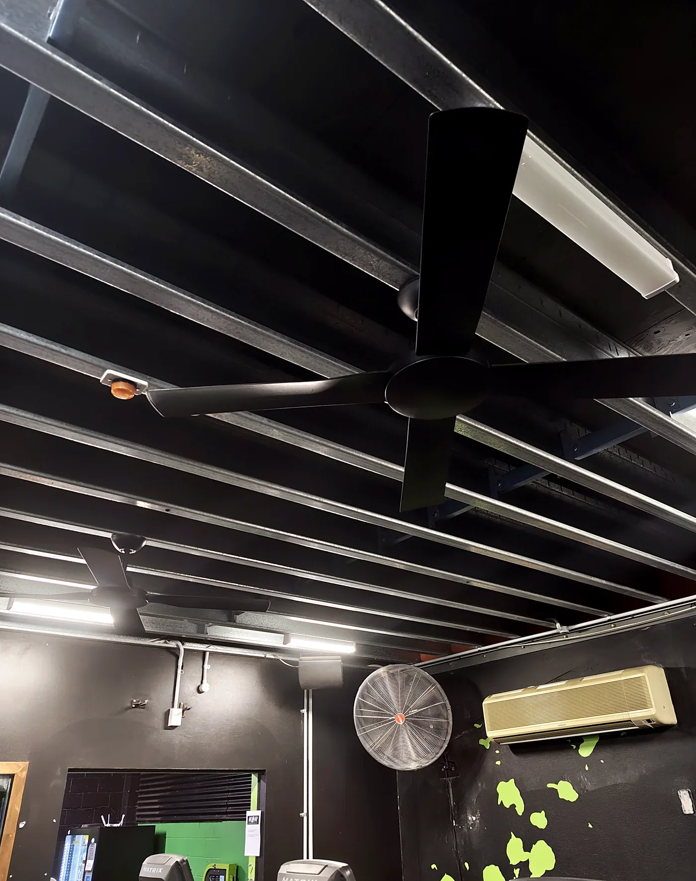 Newly installed black ceiling fans in a commercial gym
