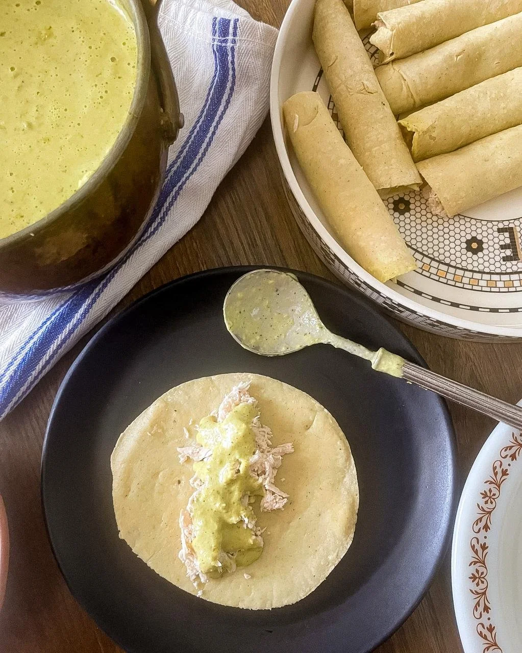Corn tortilla filled with shredded chicken and salsa verde, ready to roll