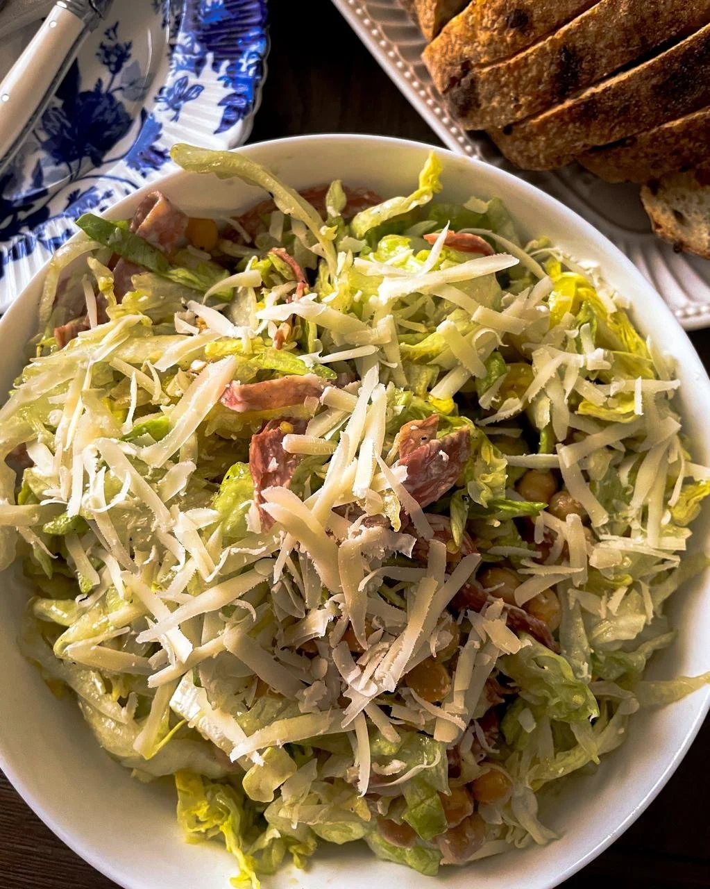 La Scala chopped salad with salami, chickpeas and parmesan in a white bowl