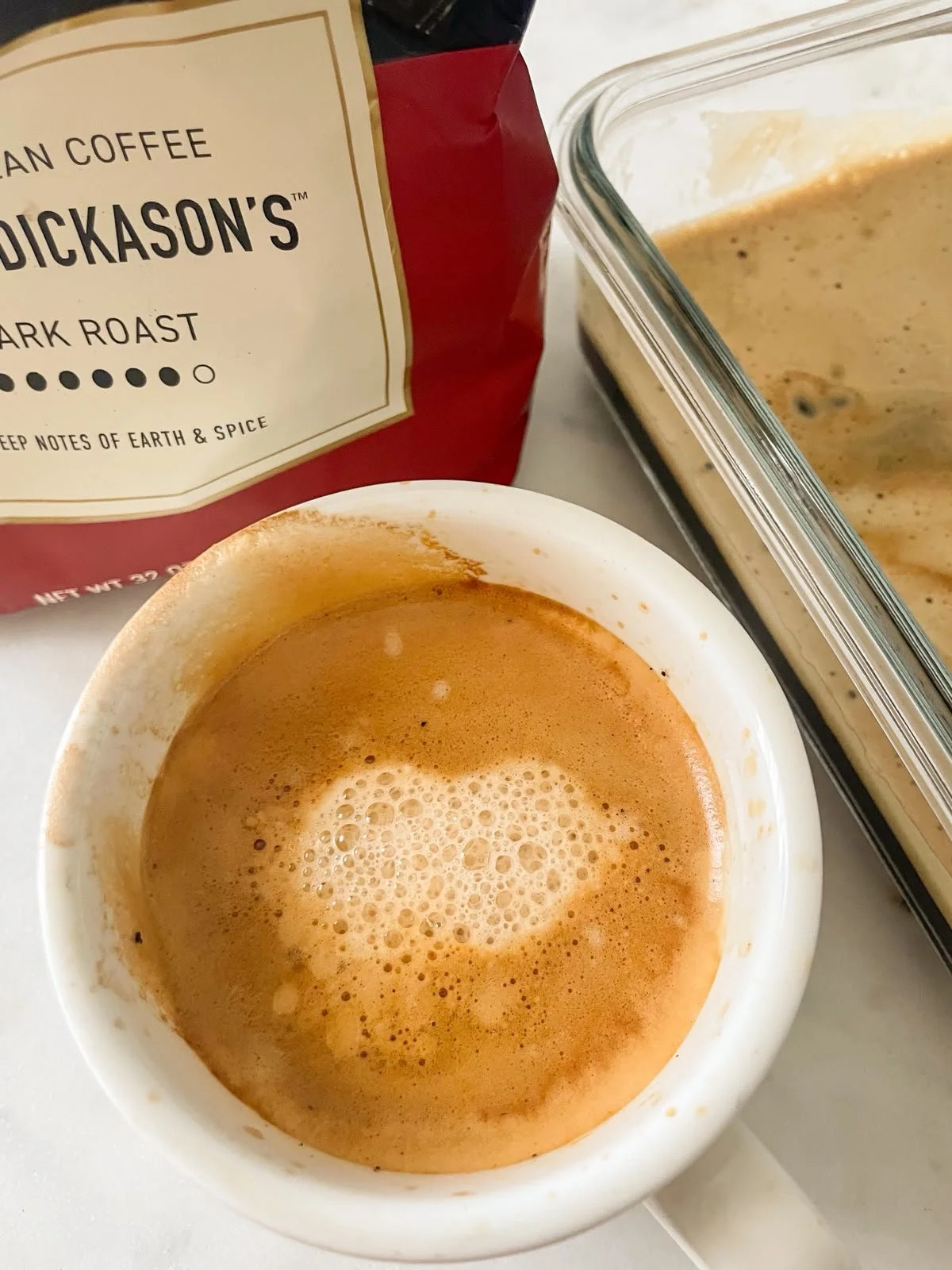 Strong brewed espresso in a white ramekin next to Major Dickason's Dark Roast coffee bag