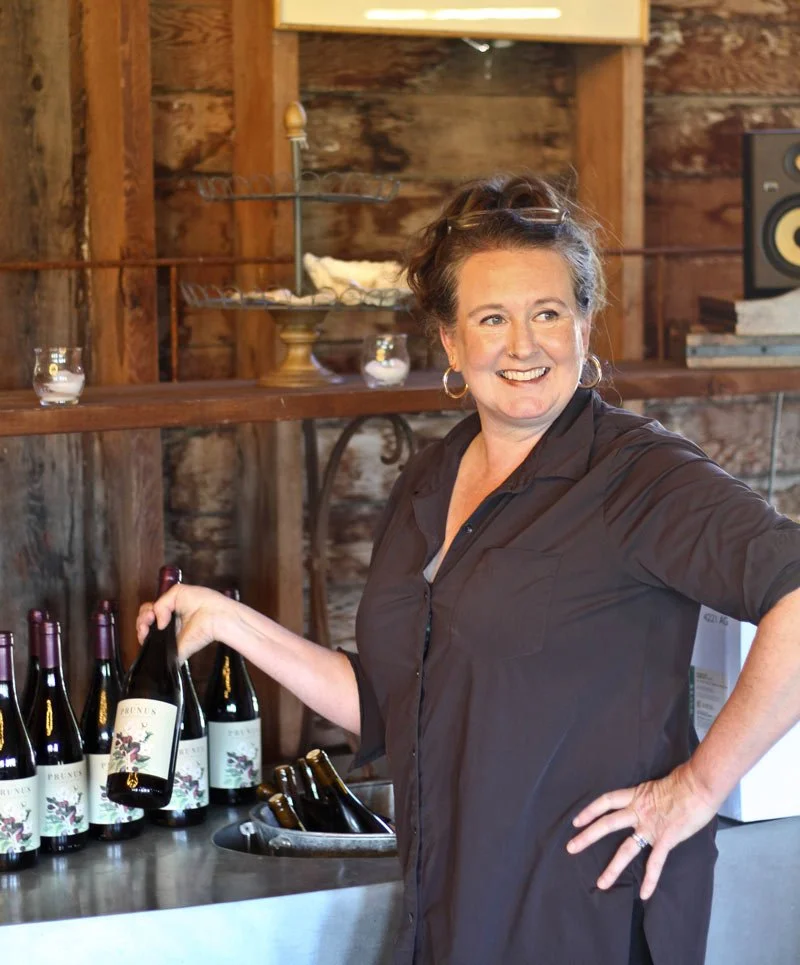 Tyla Nattress, owner/wine maven holding a wine bottle