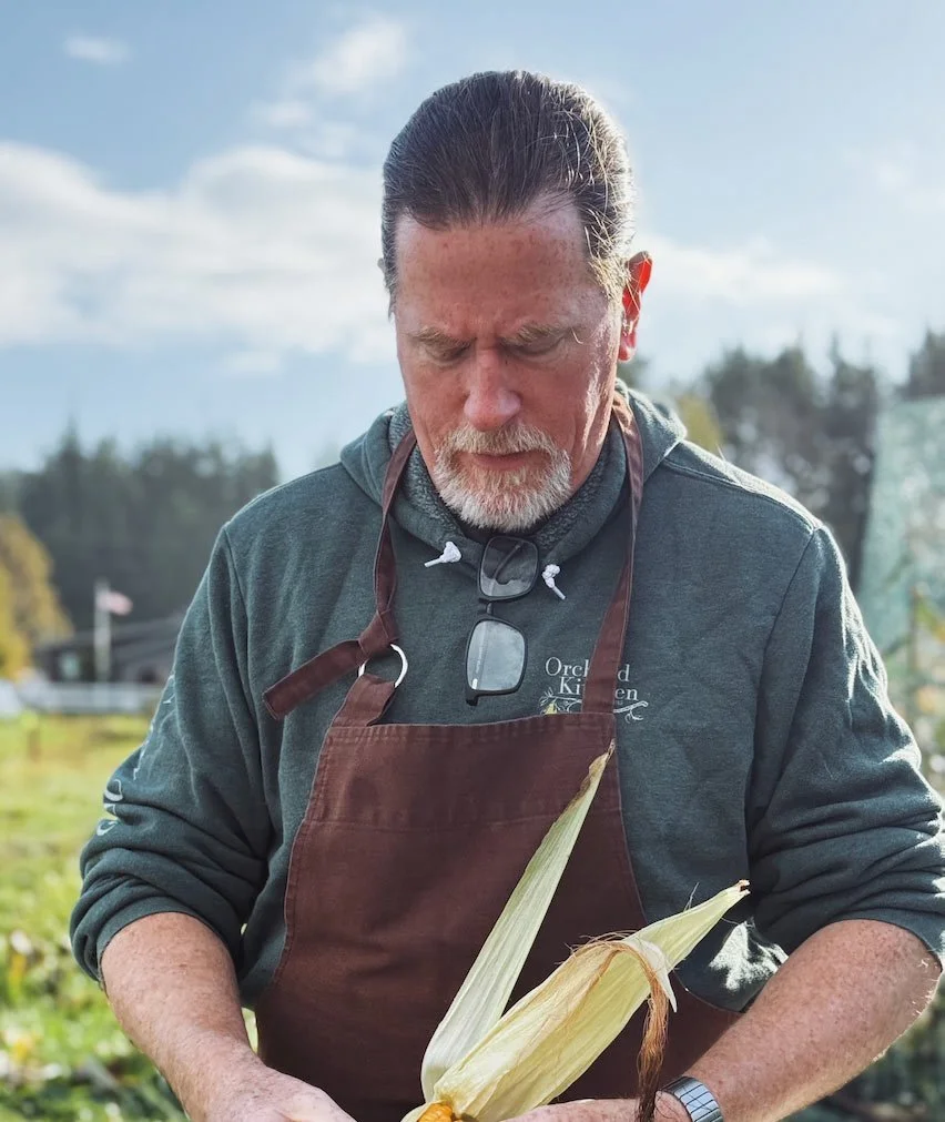 Vincent Nattress, owner and chef in garden holding corn