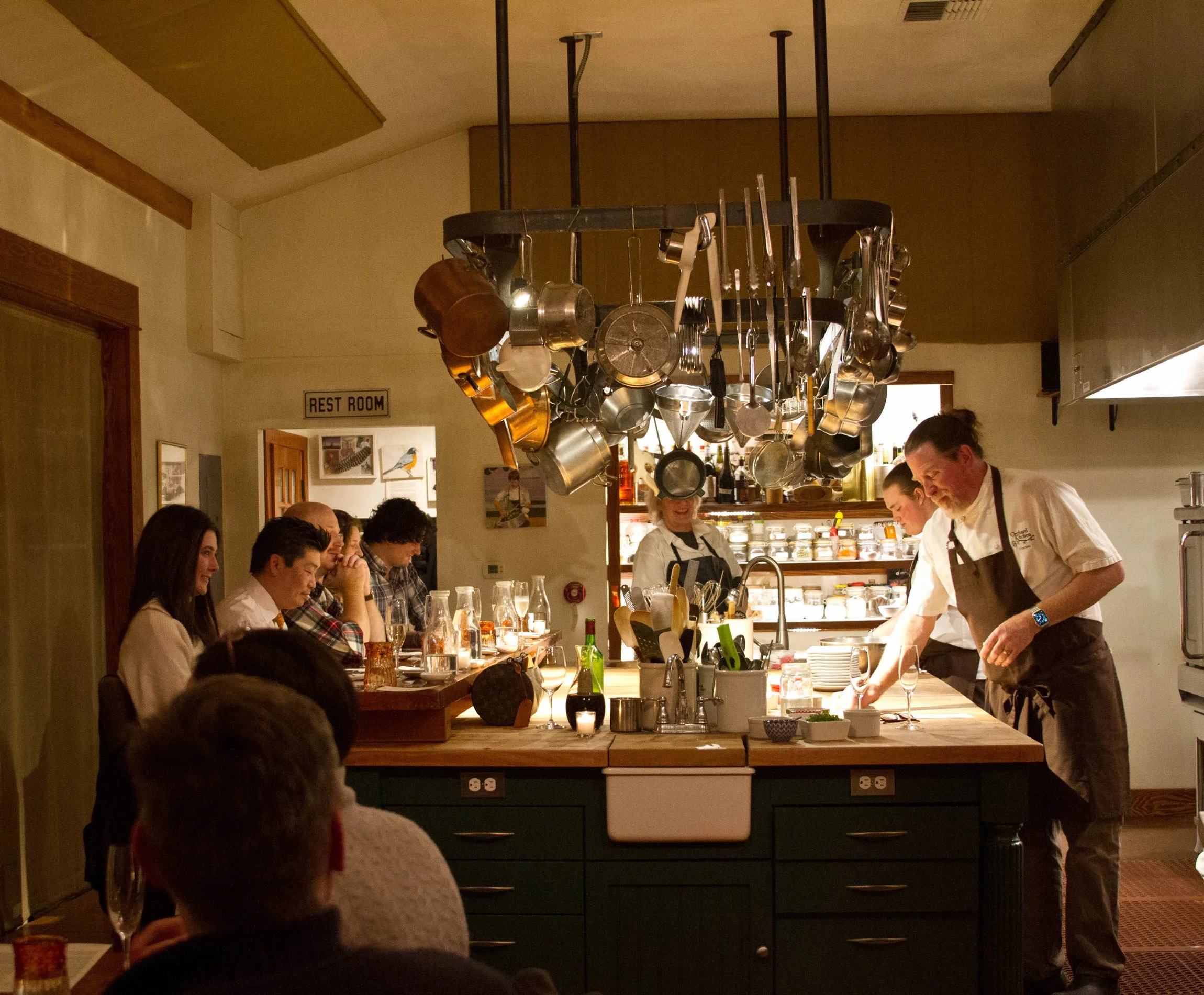 People dining around large wooden table at Orchard Kitchen