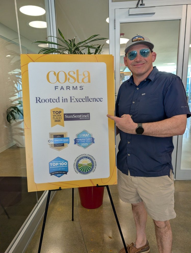 A visitor beside a Costa Farms sign