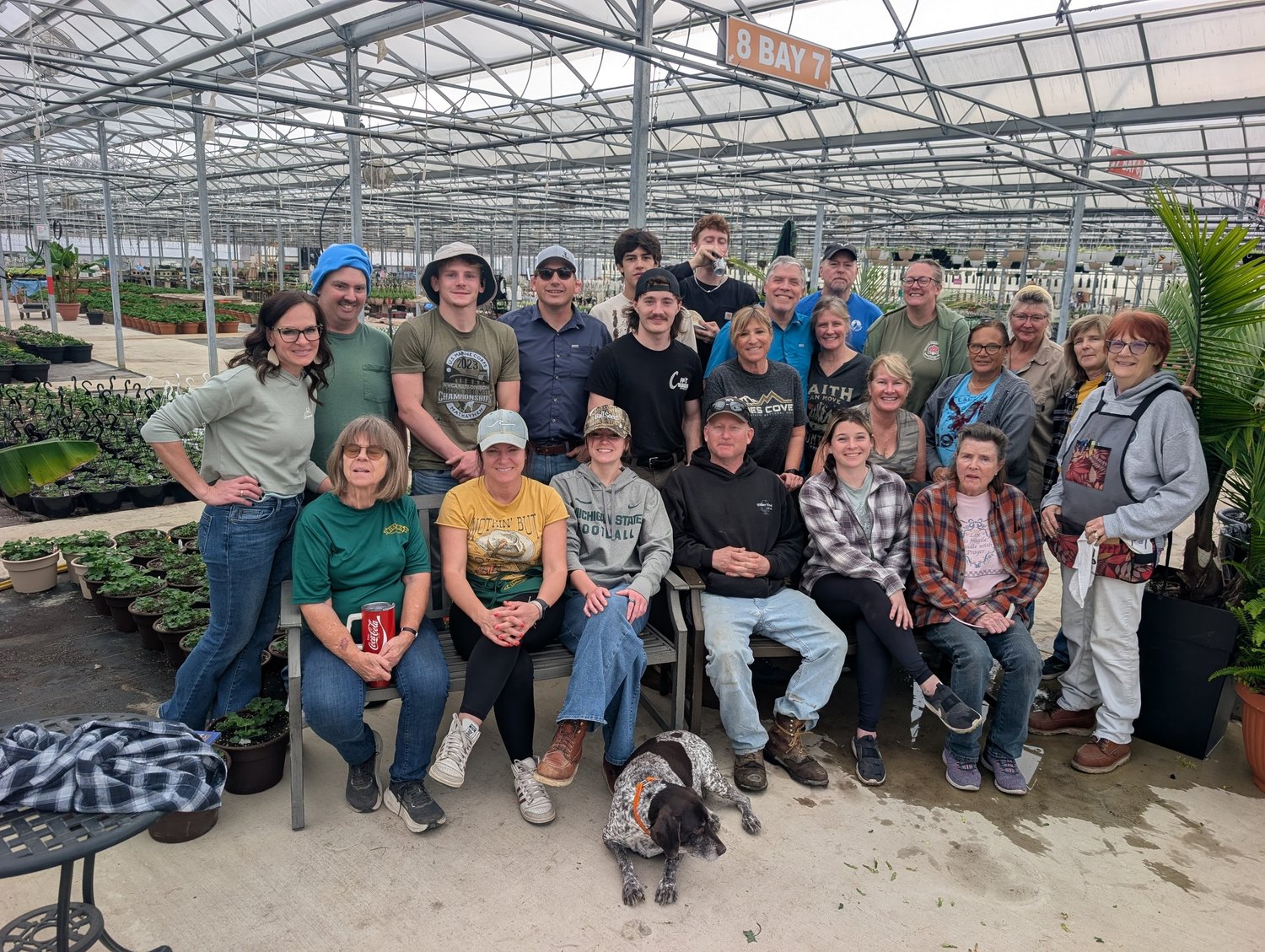 Some of Hall’s staff gathered in the greenhouse after a potluck lunch