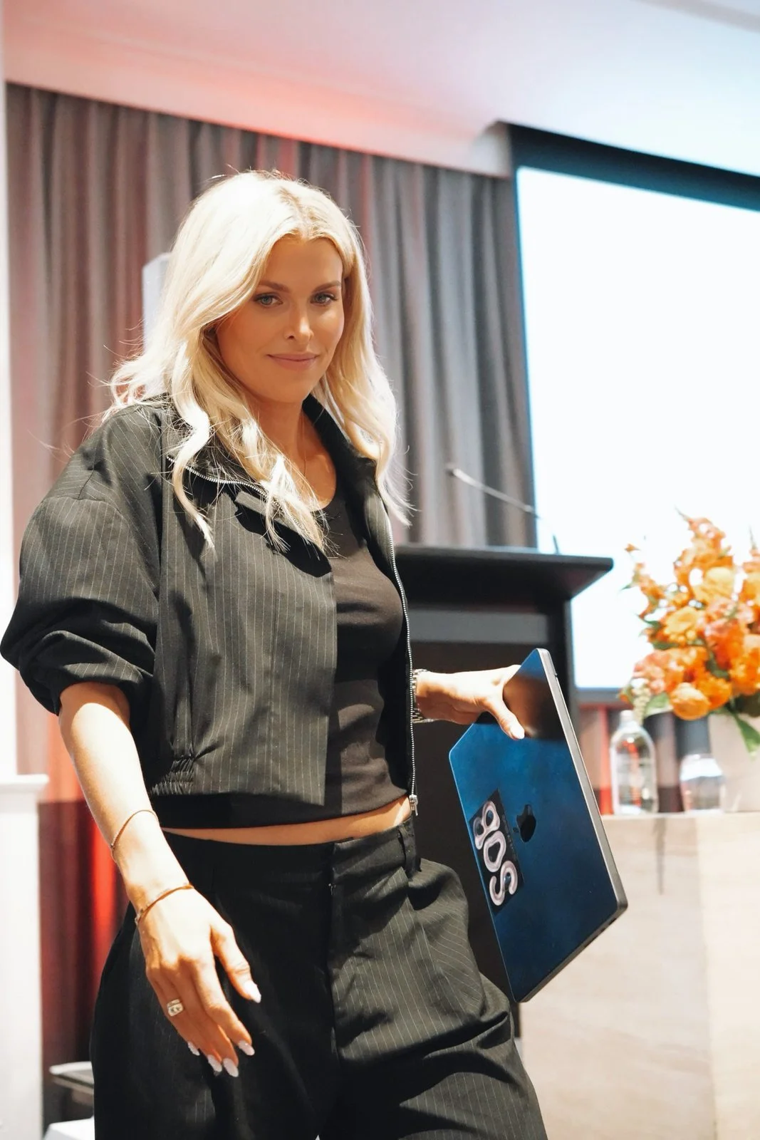 Britt on stage holding a State of Brand book
