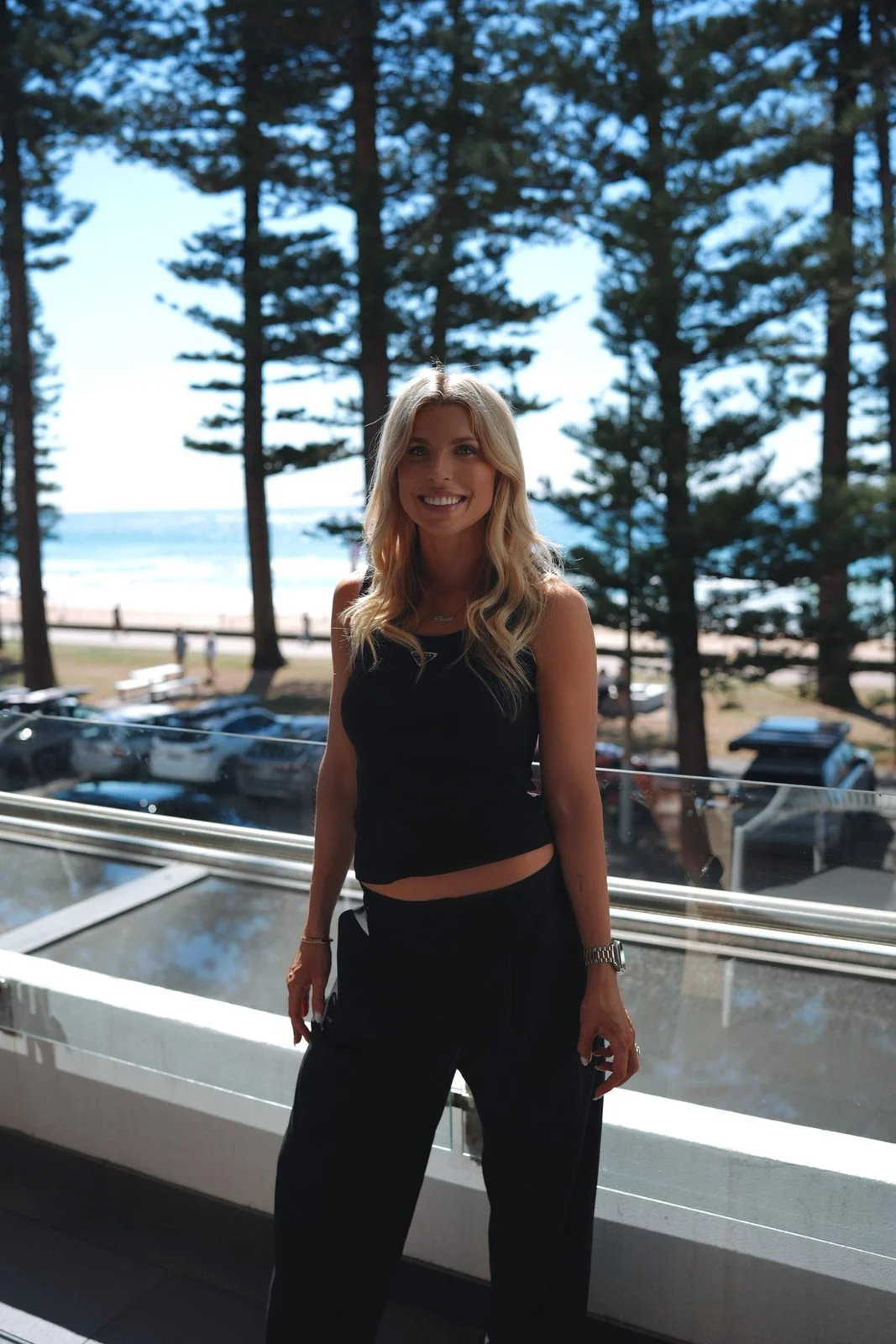 Britt Austin smiling on a terrace above the beach
