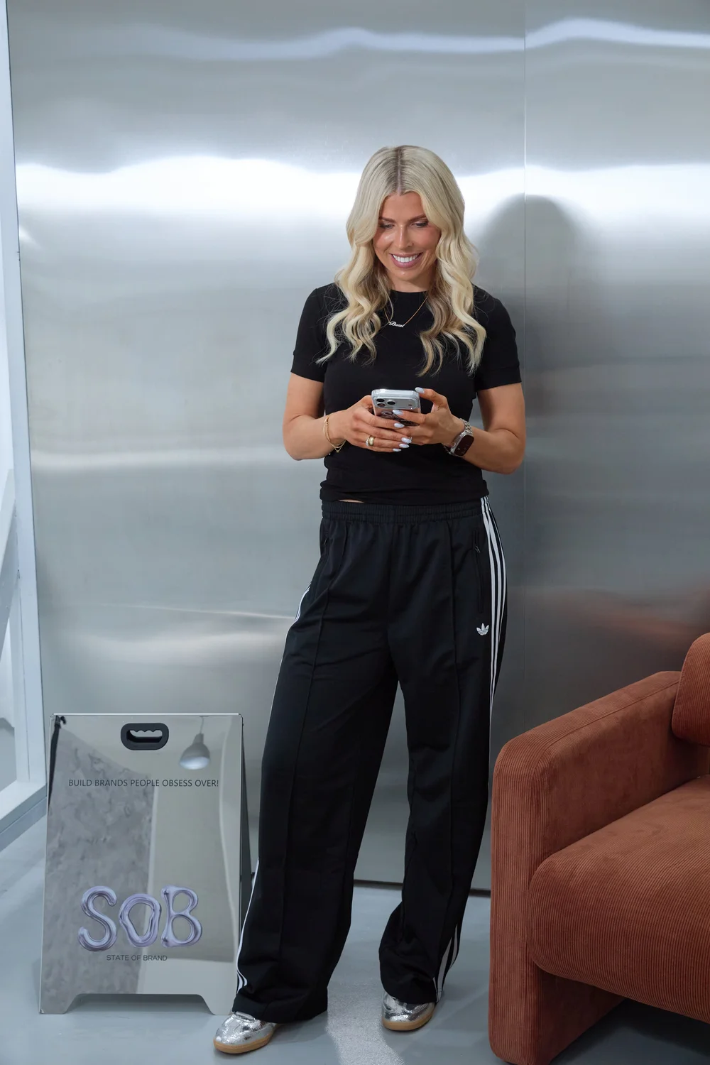 Britt on her phone against a chrome wall