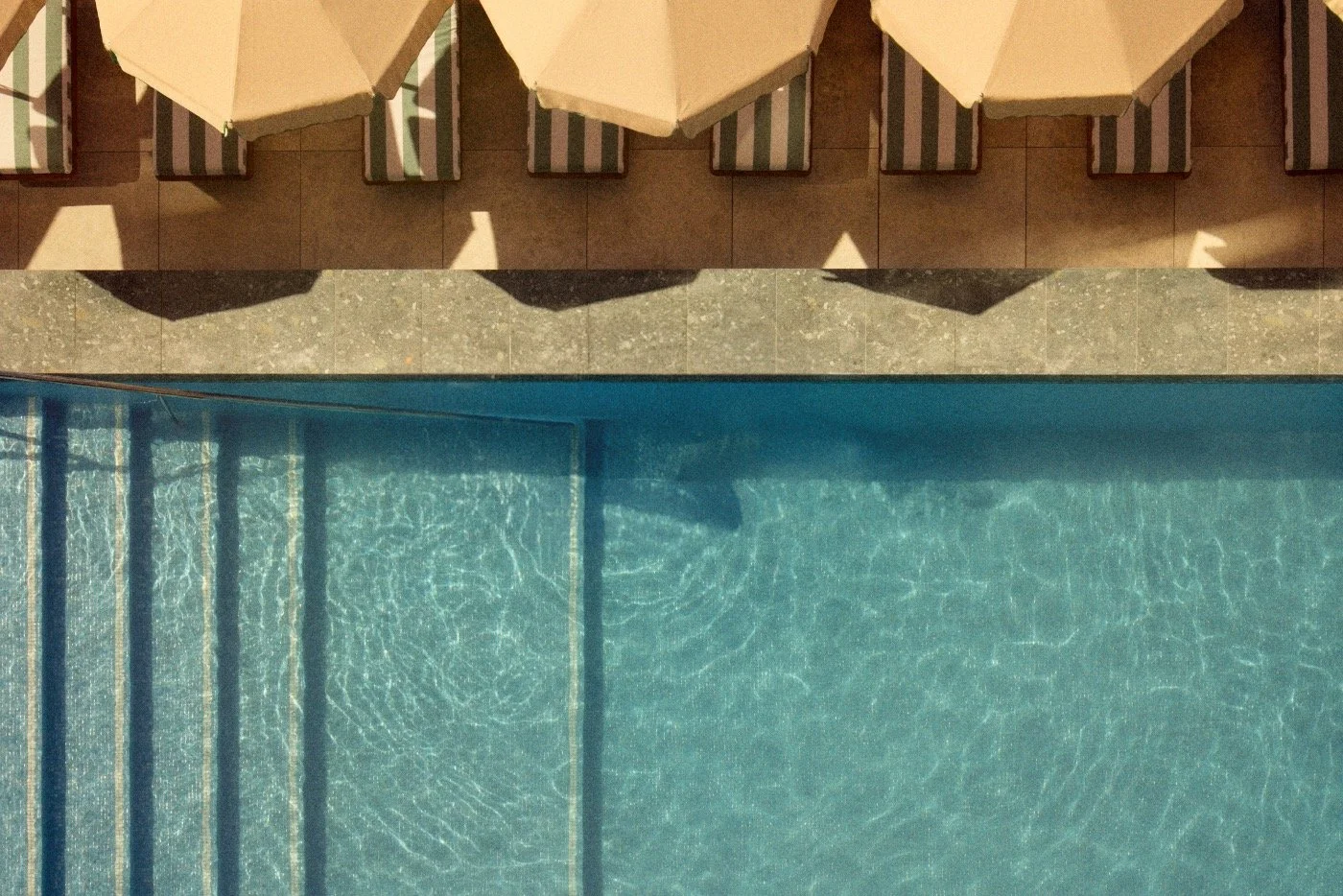 Still water and poolside umbrellas viewed from above